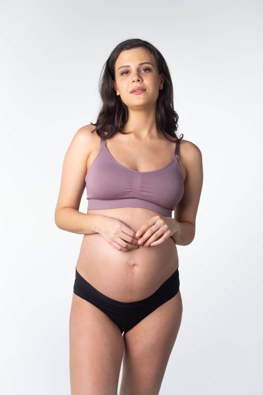 Dámska podprsenka Hotmilk My Necessity REGULAR CAP kojacia fialová (MNT-regular) M.
Dojčiaca podprsenka Hotmilk je ideálnou voľbou pre všetky nastávajúce a čerstvé mamičky, ktoré hľadajú maximálne pohodlie a podporu pre každodenné nosenie.
Kvalitný materiál pre tvoj maximálny komfort
Podprsenka Hotmilk je vyrobená z jemnej zmesi polyamidu a elastanu, ktorá zaisťuje priedušnosť, príjemný pocit na tele a dostatočnú pružnosť.
Minimalistický dizajn a praktické detaily
Dojčiaca podprsenka Hotmilk má jednoduchý, hladký strih bez zbytočných švov, ktorý sa hodí pod akýkoľvek outfit, pod oblečením je podprsenka takmer neviditeľná.
Táto podprsenka Hotmilk je ideálna pre veľkosti poprsia A - DDD.
Prečo stojí dojčiaca podprsenka Hotmilk za vyskúšanie

Prispôsobivý strih: Podprsenka sa prispôsobí dvom až trom veľkostiam košíčkov, čo zaisťuje pohodlie a flexibilitu po celú dobu tehotenstva aj po pôrode.


Jednoduché dojčenie: Praktické klipy pre jednoručné otvorenie zaisťujú ľahký prístup k prsníku, ideálny pri dojčení doma aj vonku.


Bezšvový dizajn: Hladký, bezšvový povrch zaručuje, že podprsenka nebude vidieť pod oblečením, a je tak vhodná na každodenné nosenie.


Pohodlie na každom kroku: Skvelá voľba pre nemocnicu, spanie alebo pokojné dni doma vďaka jemnému a pružnému materiálu bez kostíc.

Spodná bielizeň Hotmilk podporí tvoje sebavedomie počas tehotenstva a obdobia dojčenia
Obdobie tehotenstva a raného materstva patrí k obdobiam v živote ženy, kedy sa telo mení doslova z hodiny na hodinu.
Na prvý pohľad sa od bežnej ponuky tehotenskej a dojčiacej spodnej bielizne odlišujú podprsenky, nohavičky alebo košieľky svojim vzhľadom, pretože kladú dôraz nielen na praktickú stránku veci, ale predovšetkým na to, aby ženám pristali.
Starostlivosť o podprsenku Hotmilk
Aby ti tvoja nová obľúbená podprsenka vydržala dlho v perfektnom stave, odporúčame dodržiavať nasledujúce tipy.

Pranie: Odporúčame prať podprsenku na jemný cyklus v studenej vode a použiť ochranné vrecko na bielizeň.


Sušenie: Sušenie v sušičke neodporúčame, aby sme zachovali pružnosť a tvar podprsenky.

Tip: Aby si si túto podprsenku mohla užívať naozaj dlho, zaslúži si výnimočné zaobchádzanie.