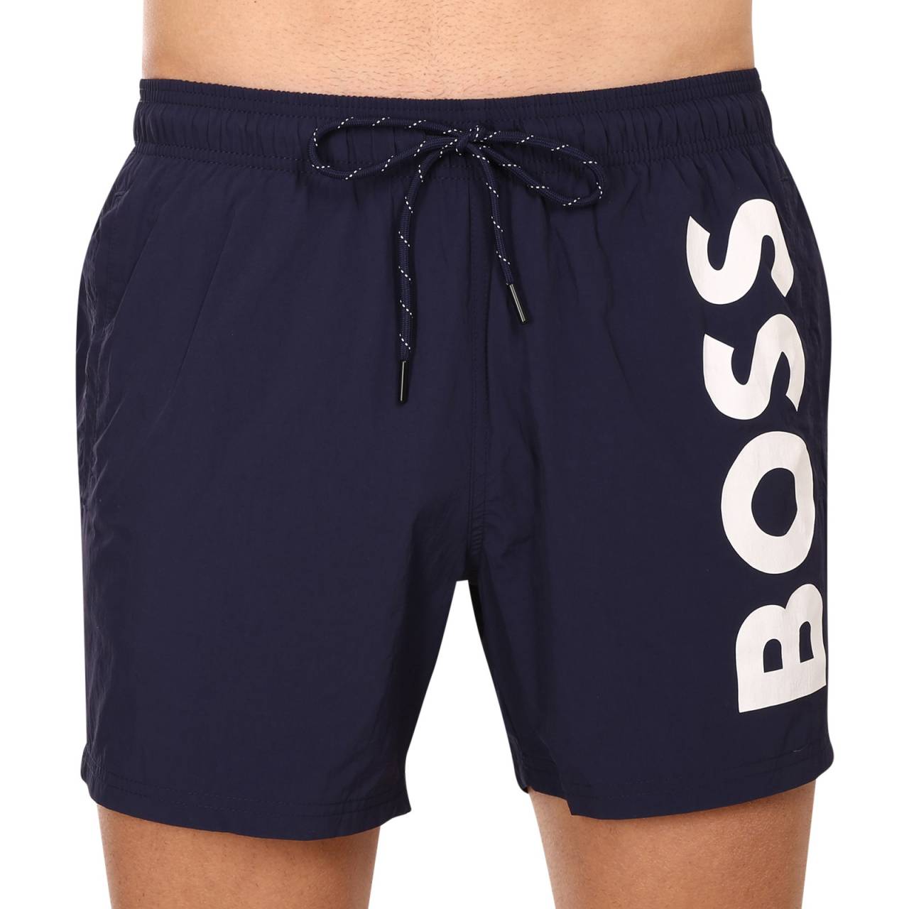 Herenzwemkleding BOSS blauw (50469602 413) L.
Ben je op zoek naar een modern en stijlvol badpak dat er niet alleen geweldig uitziet, maar ook comfort biedt?
Lichtgewicht en duurzaam materiaal
Het badpak is gemaakt van synthetische vezels die lichtgewicht, sneldrogend en bestand tegen water, chloor en zonlicht zijn.
Comfortabele snit die perfect past
De korte broeken voor heren van BOSS hebben een modern ontwerp met een sportieve touch en passen bij elke actieve man.
Waarom is BOSS zwemmode het proberen waard?

Tijdloos ontwerp: Een minimalistische en moderne look voor elke gelegenheid.
Sneldrogend materiaal: Lichtgewicht en duurzame kunstvezels voor maximaal comfort.
Ze passen perfect: Elastische taille en korte pijpen voor bewegingsvrijheid en comfort.

Alle stijlvolle mannen zullen dol zijn op BOSS ondergoed
Het merk BOSS is voortgekomen uit de bekende kledingfabrikant Hugo Boss als een productlijn voor mannen die houden van kwaliteitsstukken en tijdloze looks.
Hoe verzorg je je BOSS zwemkleding?
Om ervoor te zorgen dat je zwemkleding net zo lang meegaat als nieuwe kleding, is het belangrijk om er goed voor te zorgen:

Wasgoed: Aanbevolen voor 30°C met mild afwasmiddel.
Drogen: Niet in de droger, ideaal is om ze vrij te laten drogen aan de lucht.
Strijken: Niet strijken, het materiaal wordt vanzelf plat.

Tip: Het kan een hele klus zijn om een badpak te kiezen dat perfect bij je past en bij je stijl past.
