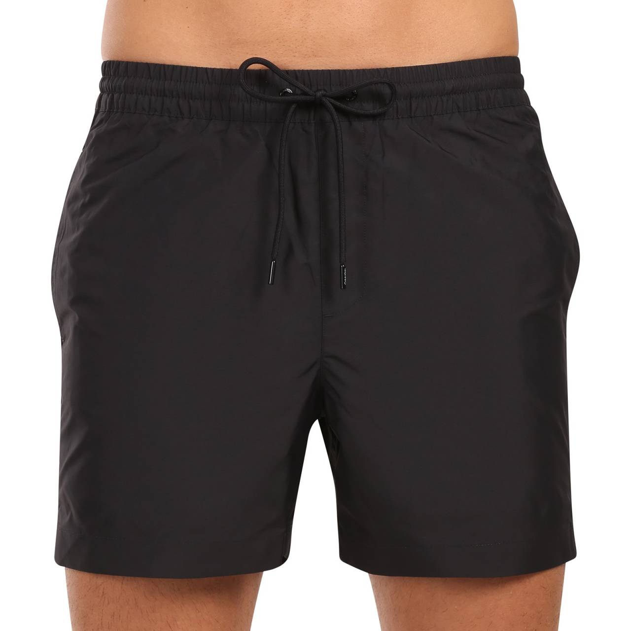 Bademode für Männer Calvin Klein schwarz (KM0KM01109-BEH) L.
Die neue Calvin Klein Bademode für Herren kombiniert das kultige Design der Marke mit modernen Elementen.
Calvin Klein-Qualität, die Sie nicht im Stich lässt
Calvin Klein Bademode wird zu 100 % aus recyceltem Polyester hergestellt, was eine hohe Qualität gewährleistet und gleichzeitig die Nachhaltigkeit fördert.
Durchdachtes Design für Ihren Komfort
Calvin Klein Bademode ist auf Komfort und Stil ausgerichtet.
Warum sollte Calvin Klein Bademode in Ihrem Kleiderschrank nicht fehlen?

Nachhaltigkeit: Die Bademode wird aus recycelten Materialien hergestellt, was die Auswirkungen auf die Umwelt reduziert.
Schnell trocknende Technologie: Das moderne Material bietet Ihnen den ganzen Tag über maximalen Komfort.
Elegantes und modernes Design: Calvin Klein kommt einfach nie aus der Mode.
Perfekte Wahl: Sie werden nicht nur am Strand, sondern auch bei Poolpartys oder beim Wassersport ein Star sein.

Calvin Klein Unterwäsche verleiht Ihnen einen einzigartigen Stil
Calvin Klein Herrenunterwäsche gehört zu den Aushängeschildern der Modeindustrie.
Pflegehinweise für Calvin Klein Bademode
Damit die Calvin Klein Bademode lange ihre Qualität und Farbe behält, ist es wichtig, die richtigen Pflegemaßnahmen zu ergreifen.

Waschen: Waschen Sie sie in der Waschmaschine bei maximal 30 °C und verwenden Sie ein mildes, materialschonendes Waschmittel.
Trocknen: Trocknen Sie Ihren Badeanzug nicht im Trockner, sondern lassen Sie ihn an der Luft im Schatten trocknen, damit die leuchtend rote Farbe nicht ausbleicht.
Lagerung: Lagern Sie den Badeanzug nach dem vollständigen Trocknen an einem trockenen und gut belüfteten Ort, um Schimmelbildung zu vermeiden.

Tip: Es kann schwierig sein, die richtige Unterwäsche zu finden, die perfekt sitzt.